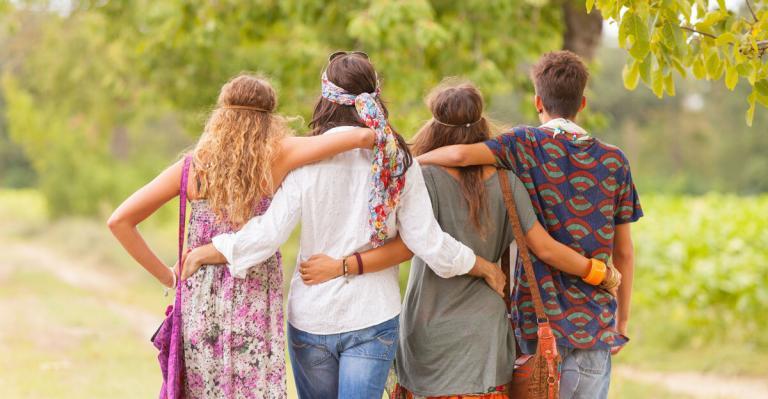 2 hippie couples arms entwined view from back
